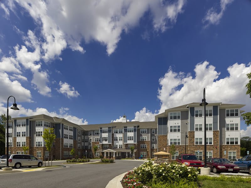 A modern residential building under a partly cloudy sky.
