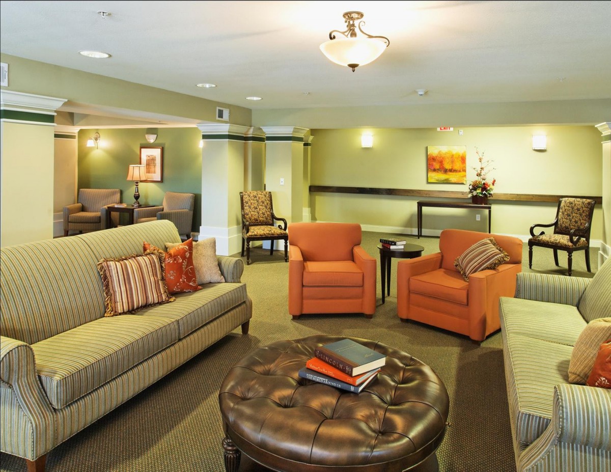 A cozy living room with comfortable sofas, armchairs, and a large coffee table.