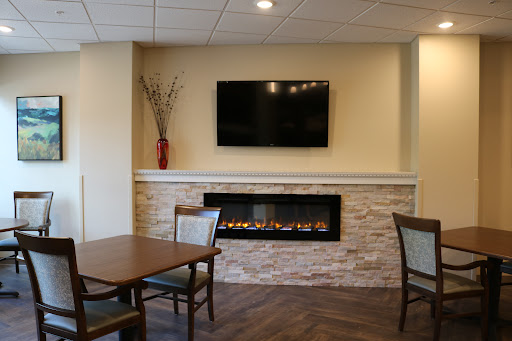 A cozy lounge area featuring a modern fireplace and television.