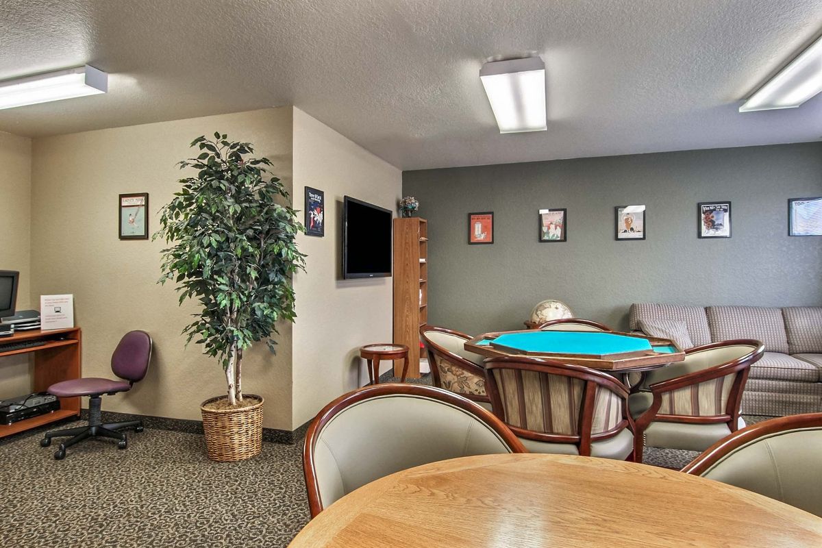 A cozy common room with seating, a television, and decorative elements.