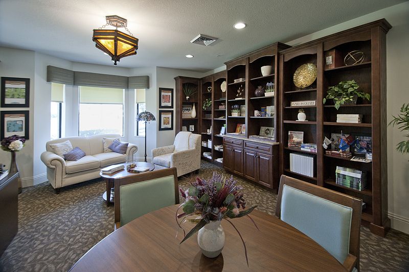 A cozy living room with an expansive bookshelf, comfortable seating, and stylish decor.