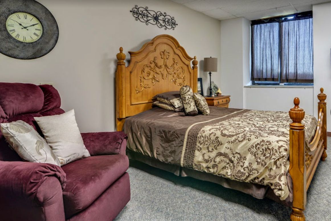 A cozy bedroom with a wooden headboard and patterned bedding.
