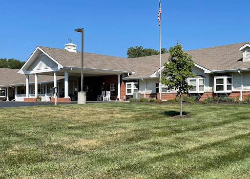 A sunny day at a care facility, showcasing the well-maintained lawn and welcoming entrance.