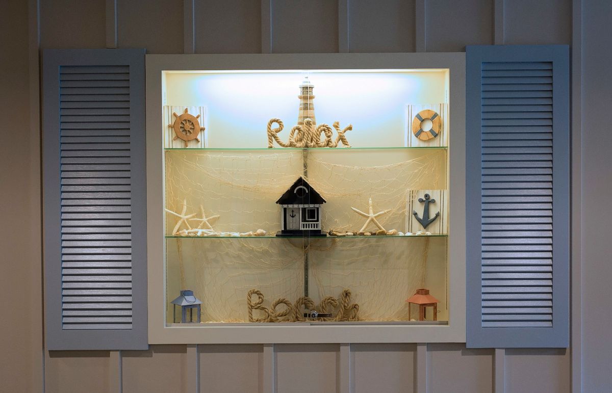 A nautical-themed window display featuring decorative elements like starfish, anchors, and the word 'Relax'.