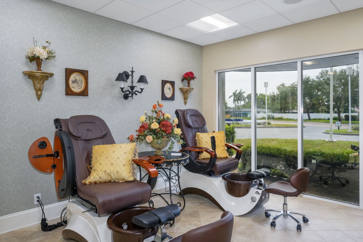 A cozy nail salon featuring comfortable pedicure chairs and elegant decor.