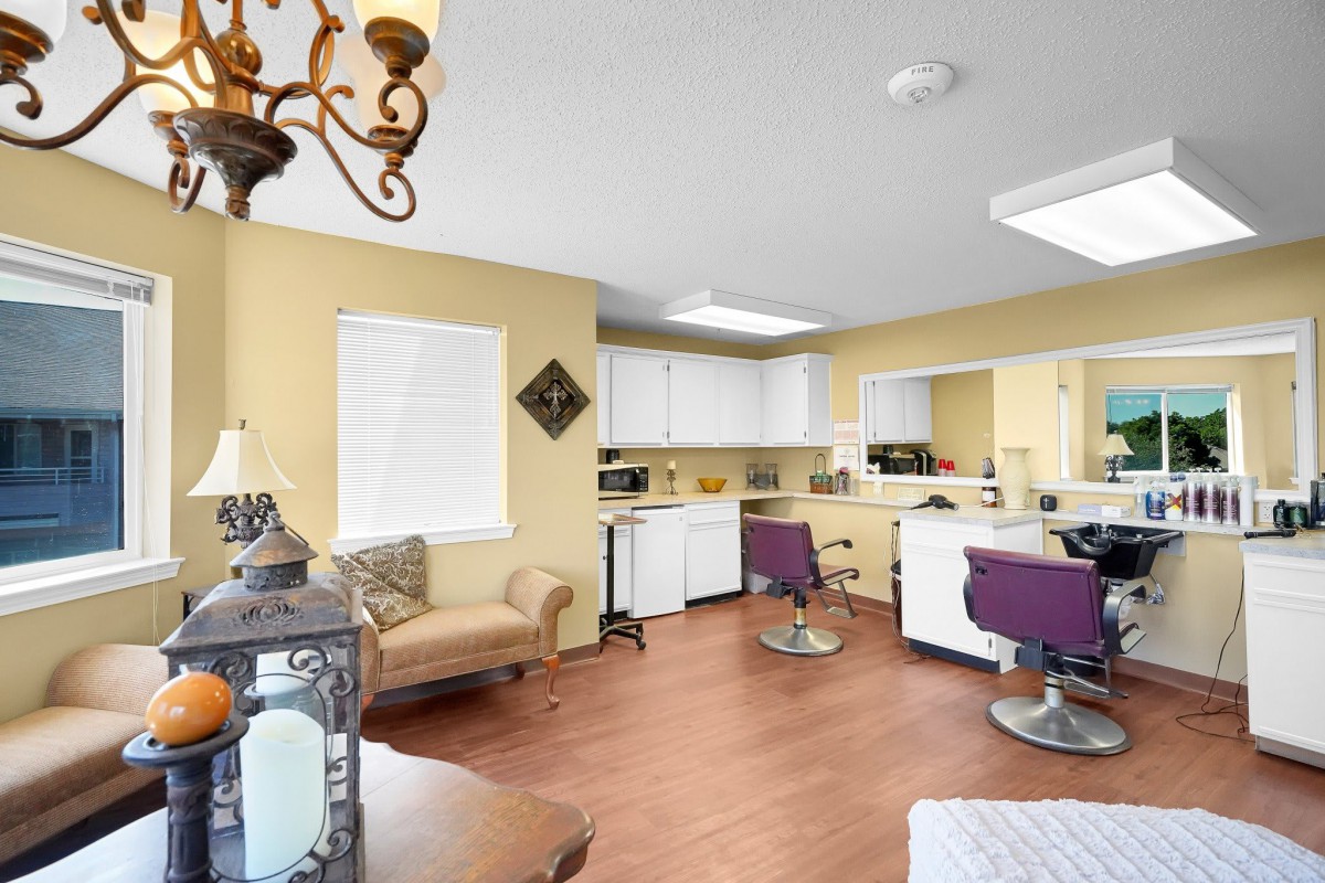 A well-lit beauty salon interior with styling stations and comfortable seating.