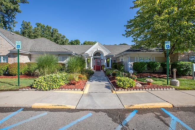 A house surrounded by a well-maintained garden and pathway on a sunny day.