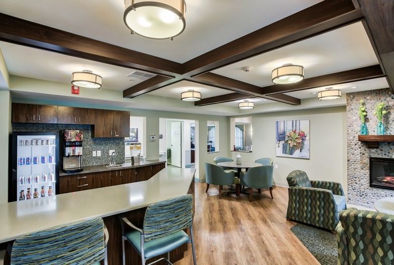 A modern interior featuring a kitchen and dining area with stylish lighting and wooden flooring.