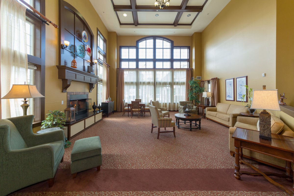 A spacious lobby with comfortable seating, large windows, and a fireplace.
