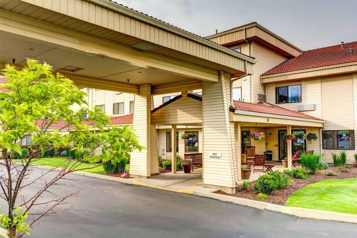 A welcoming hotel entrance with a covered driveway and landscaped surroundings.