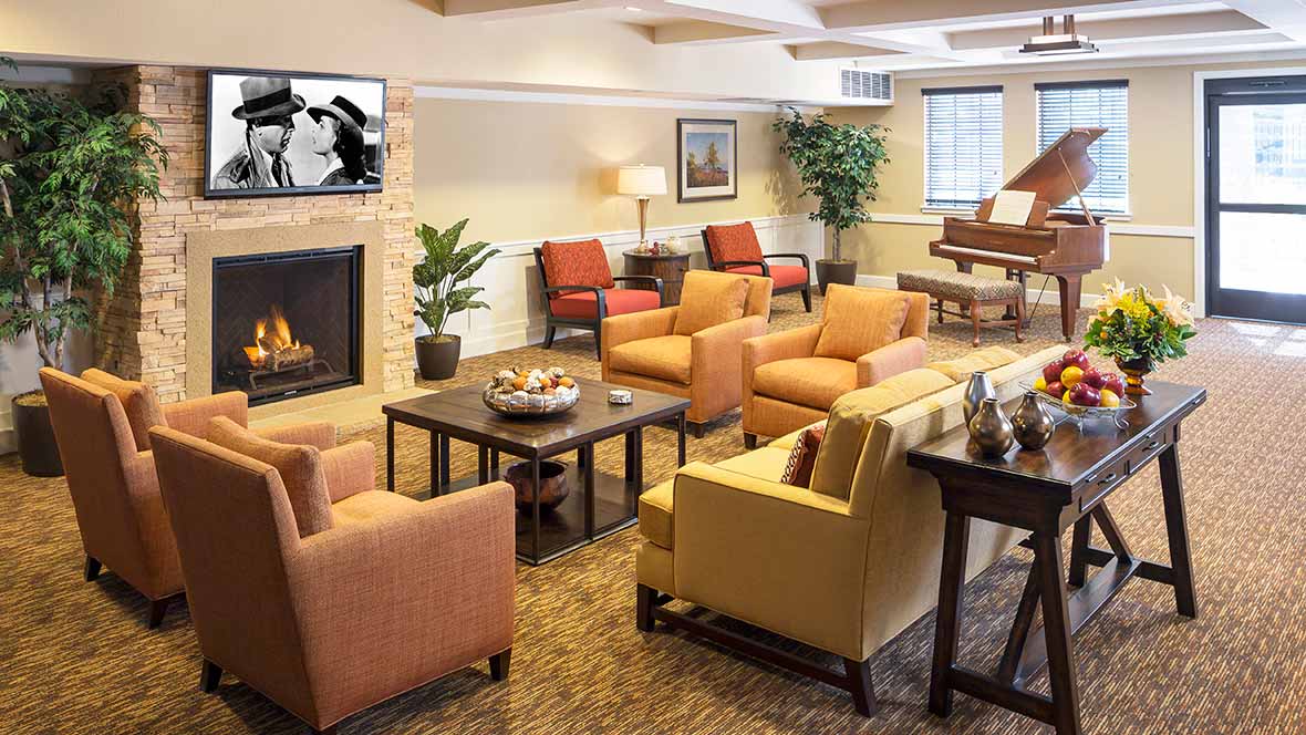 A cozy living room with comfortable seating, a fireplace, and a piano.