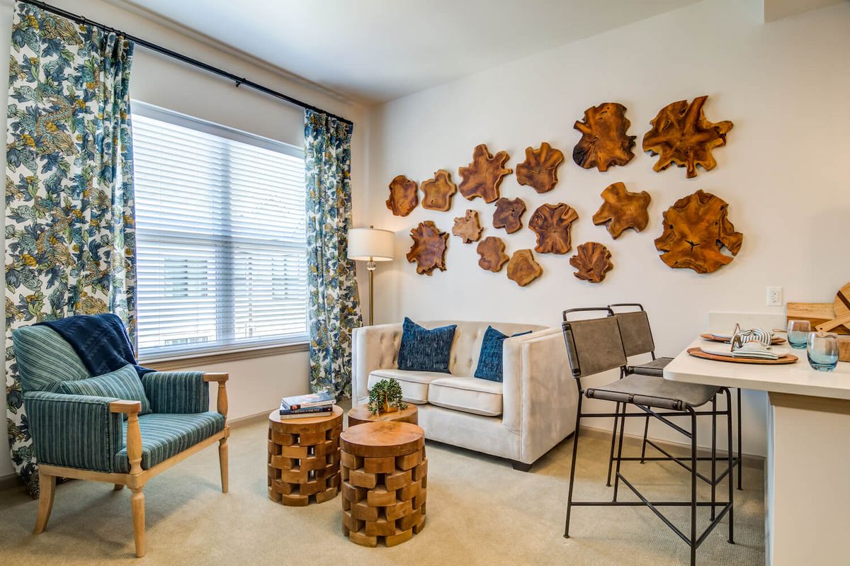 A stylish living room featuring modern furniture and wooden wall art.