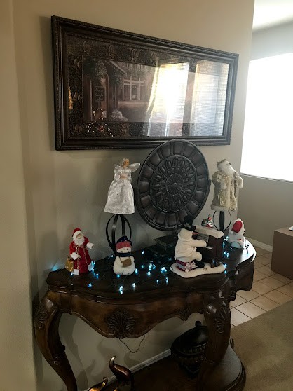 A table adorned with Christmas-themed figurines and decorations, adding a festive touch to the home's interior.