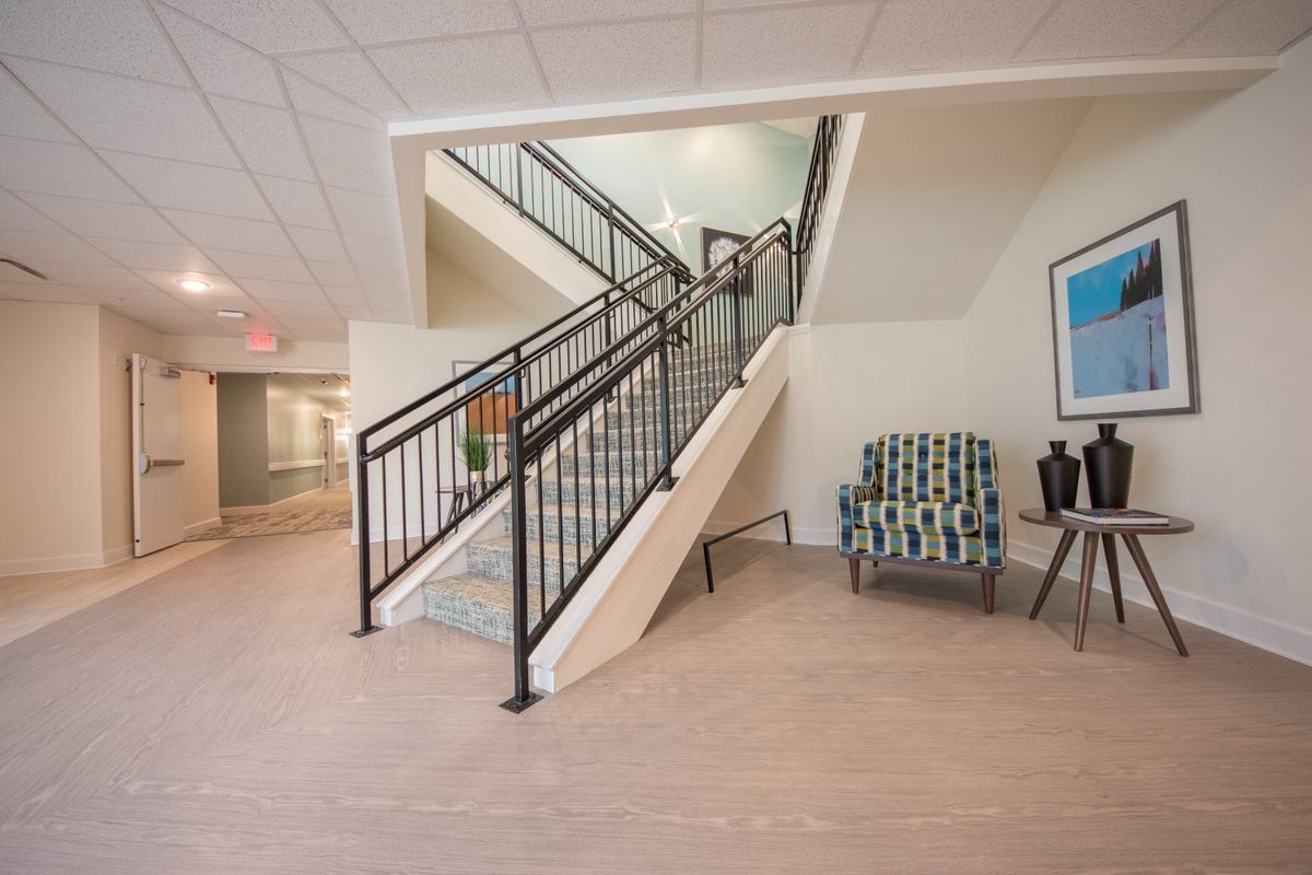 Modern lobby with a central staircase and seating area.