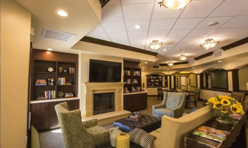 A cozy living room with comfortable seating, a fireplace, and a television.