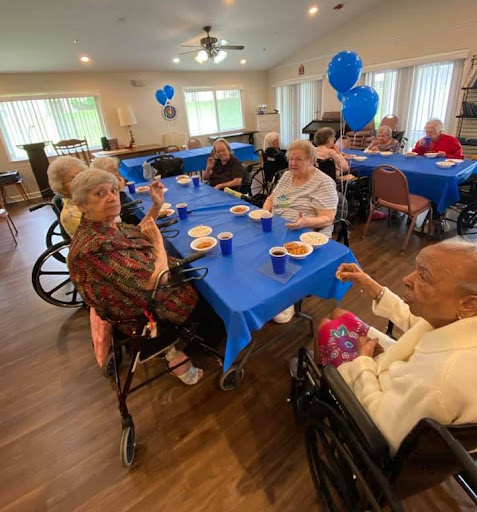 Seniors enjoying a lively gathering with festive blue decorations.