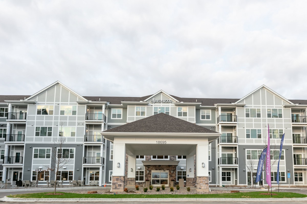 A modern apartment building with large windows and a prominent entrance.