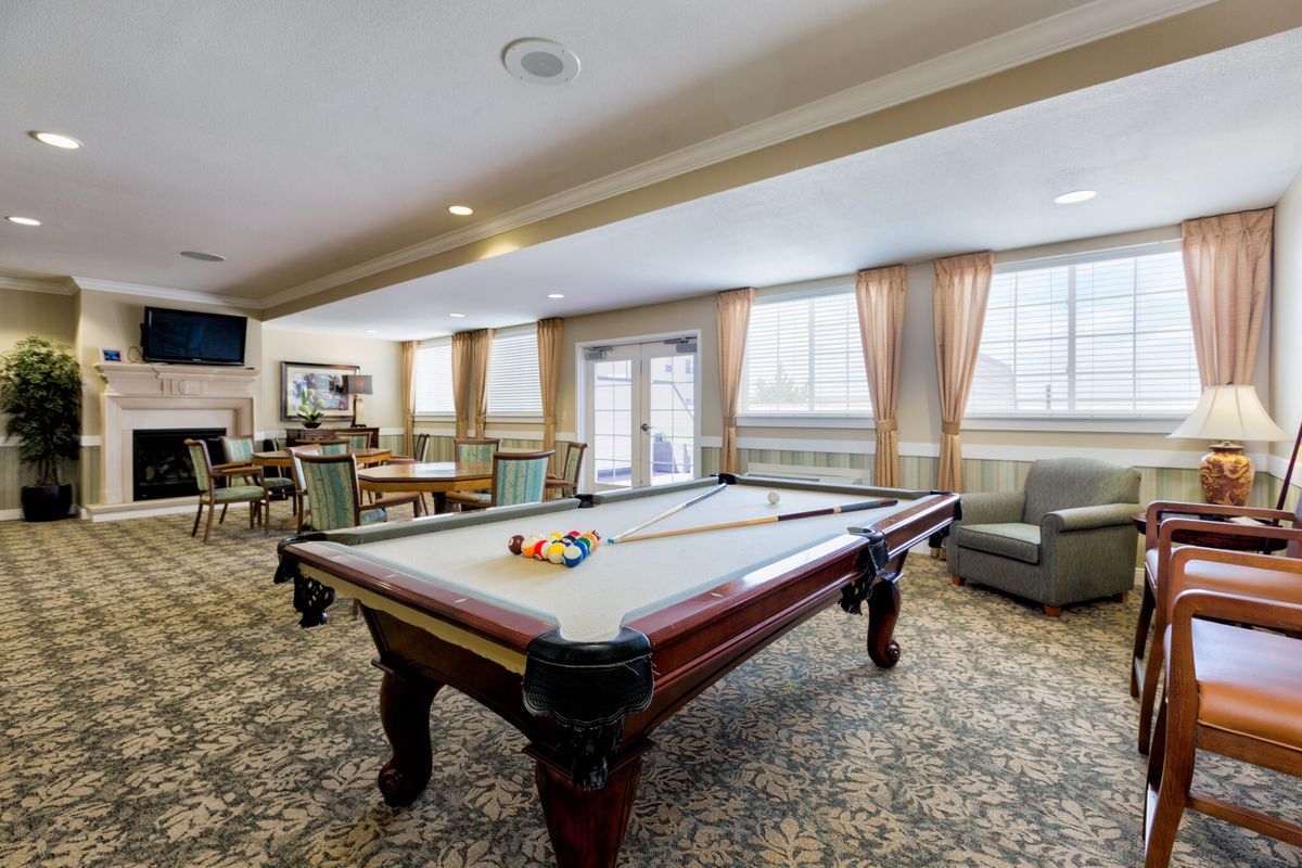 A cozy game room featuring a pool table and comfortable seating.
