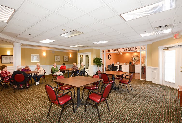 A spacious cafe interior with tables, chairs, and people enjoying their meals.
