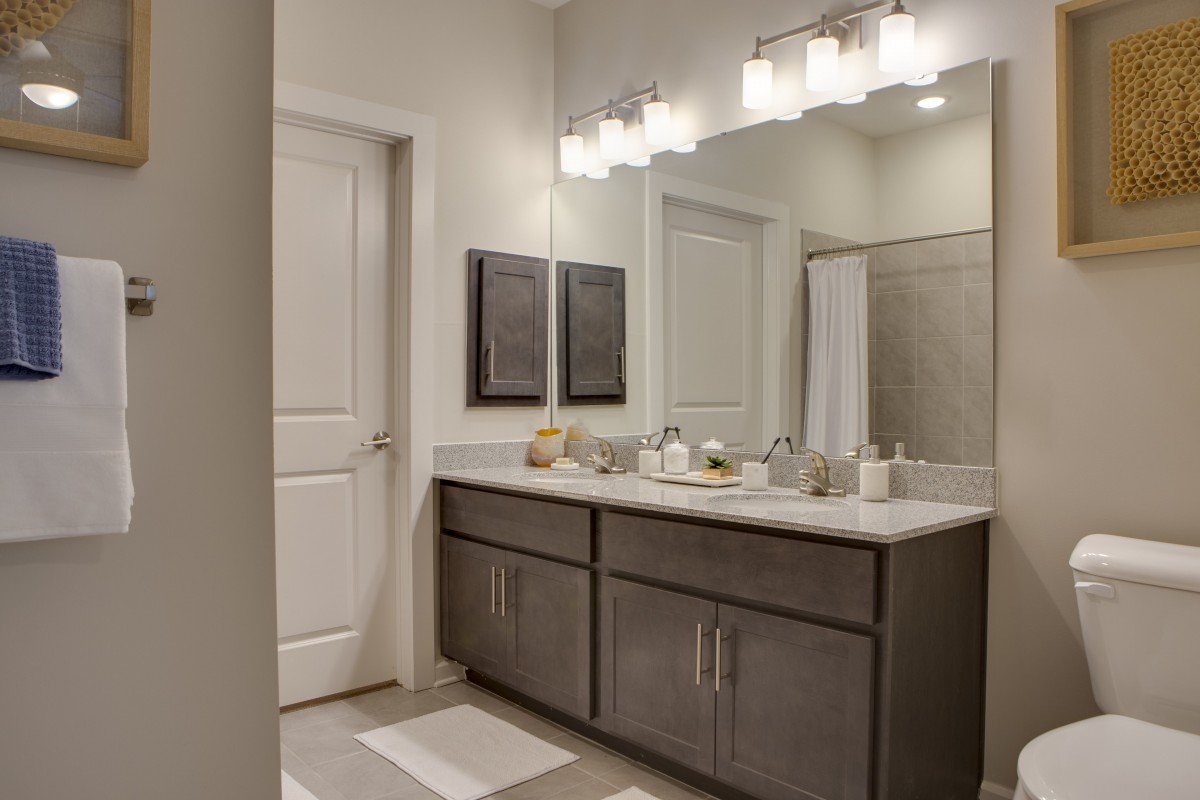 A modern bathroom with a double sink and elegant lighting.