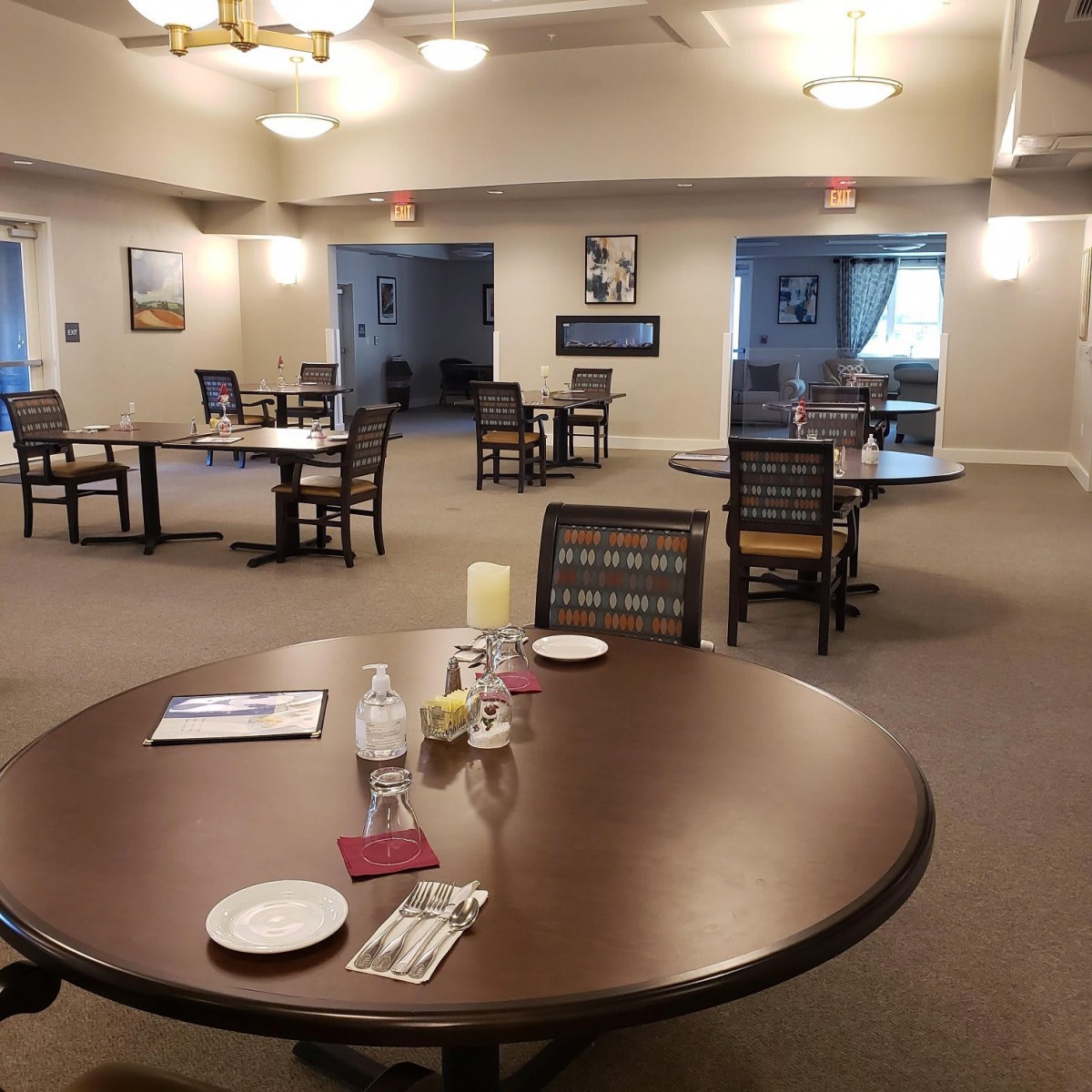 An empty dining area with several tables and chairs arranged in a well-lit space.