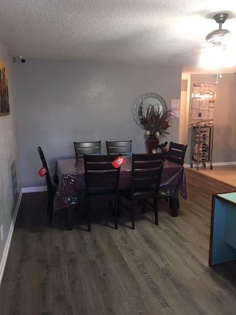 A cozy dining area with a table set for six, complemented by wood flooring and minimalist decor.