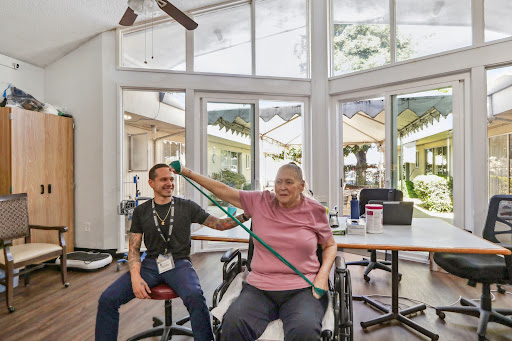 A patient engages in physical therapy with the assistance of a caregiver, focusing on rehabilitation and wellness.