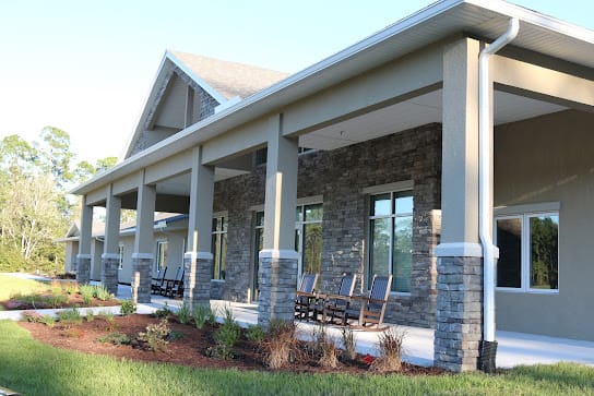 A modern house with a stone facade and spacious porch area.