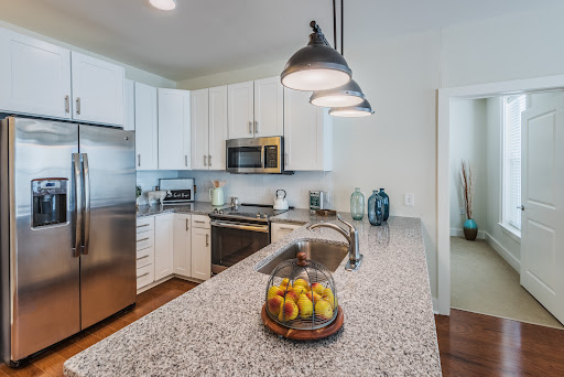A modern kitchen featuring a sleek countertop, stainless steel appliances, and stylish pendant lighting.