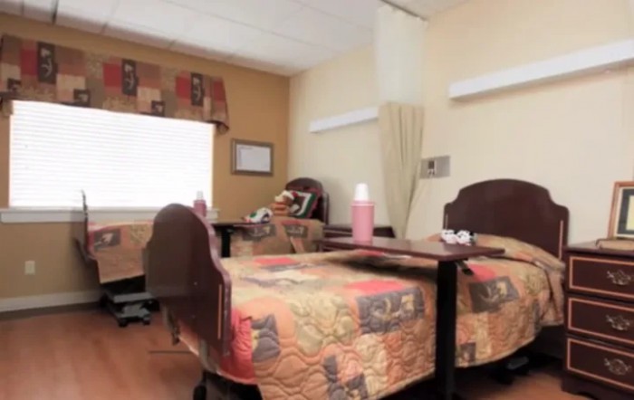 A hospital room with two beds and bedside tables.