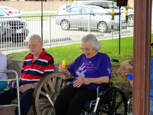 Two elderly individuals enjoying a sunny day at a park.