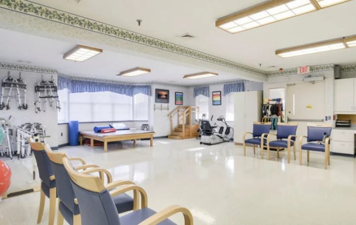 A spacious rehabilitation center with exercise equipment and a waiting area.