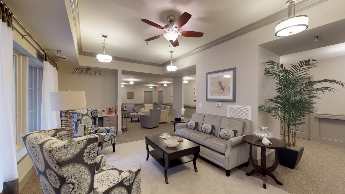 A cozy living room with a sofa, coffee table, and elegant lighting fixtures.
