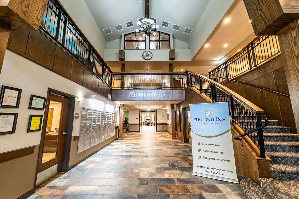 A spacious and elegantly designed lobby with a grand staircase and a welcome sign.