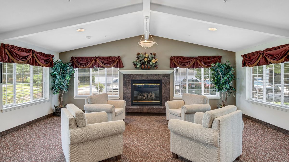 A cozy living room with a central fireplace surrounded by sofas.