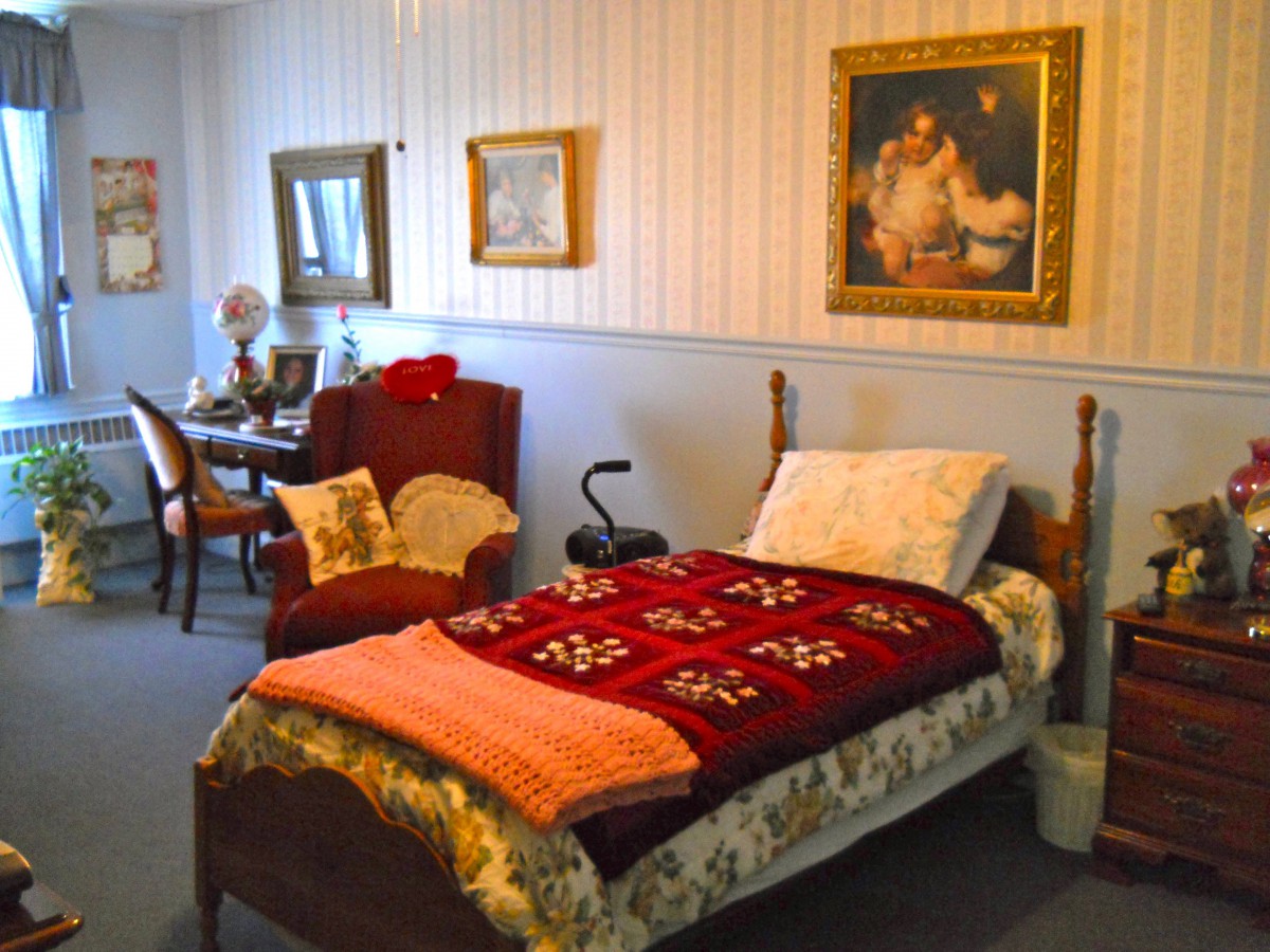A cozy bedroom with vintage furniture and decorative paintings on the walls.