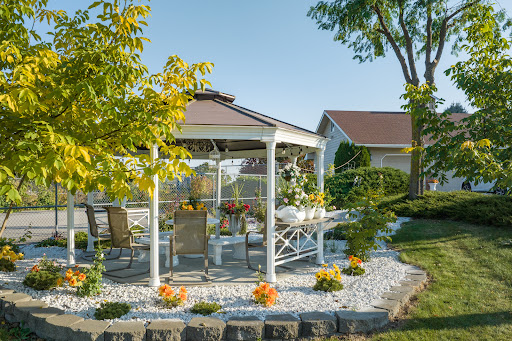 A serene garden gazebo surrounded by lush greenery and beautiful flowers, perfect for outdoor relaxation.