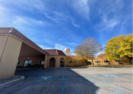 A picturesque view of a building surrounded by autumn foliage under a clear blue sky.