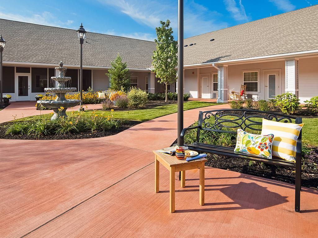A serene courtyard with a fountain, surrounded by landscaped gardens and outdoor seating.