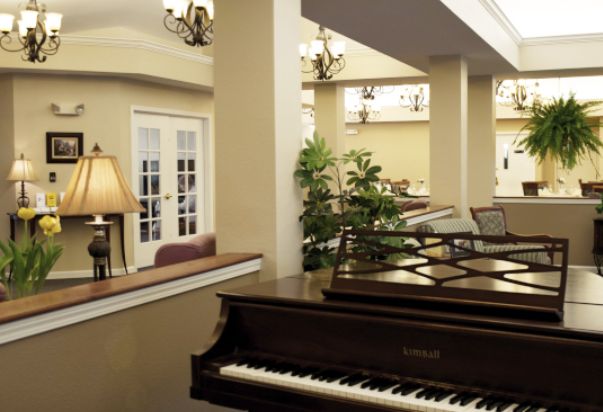 Elegant living room interior featuring a grand piano and classic chandeliers.