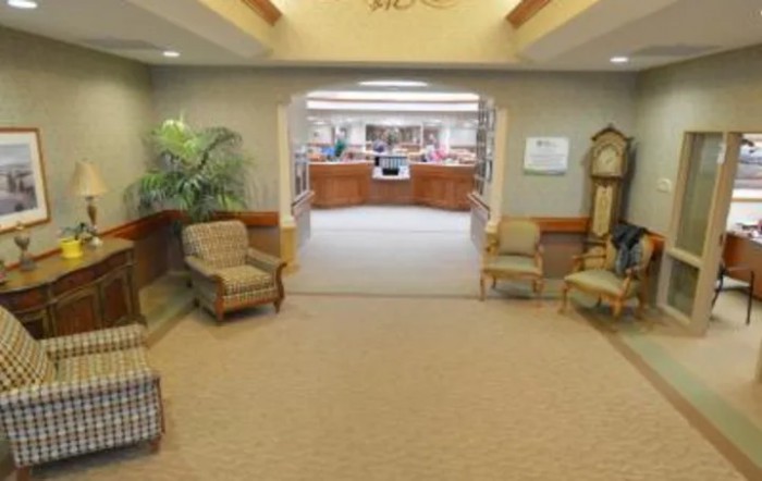 A lobby area featuring comfortable chairs and a view of the reception desk.