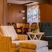 A retro living room featuring vintage armchairs and wood paneling.
