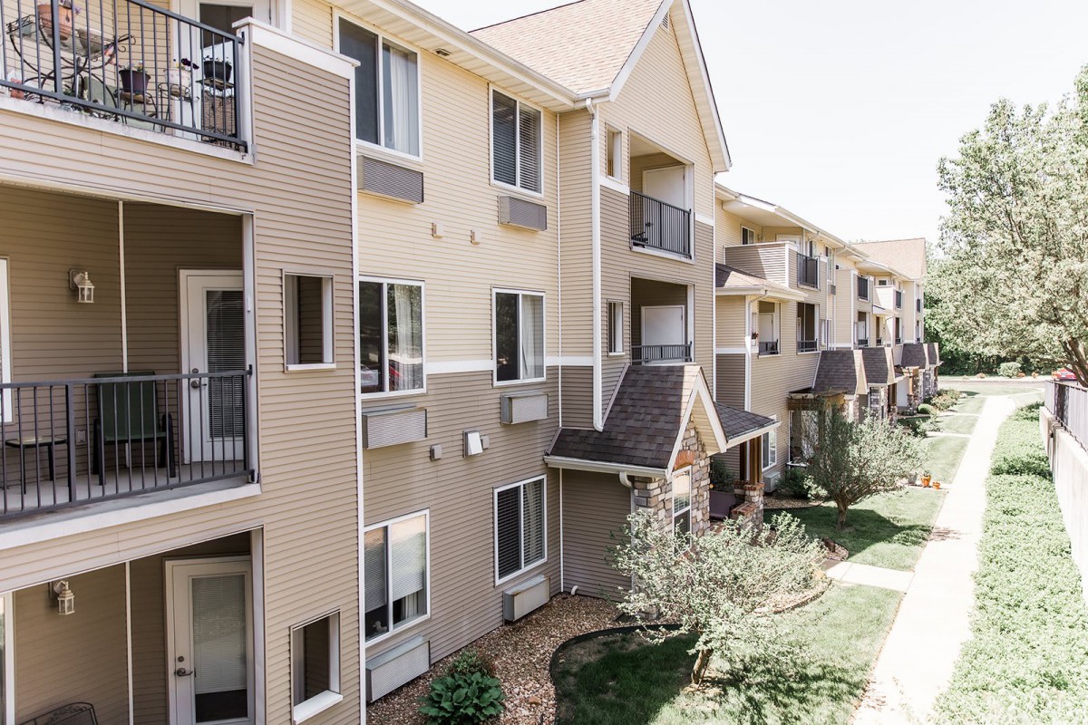 A multi-story apartment building with balconies and well-maintained landscaping.