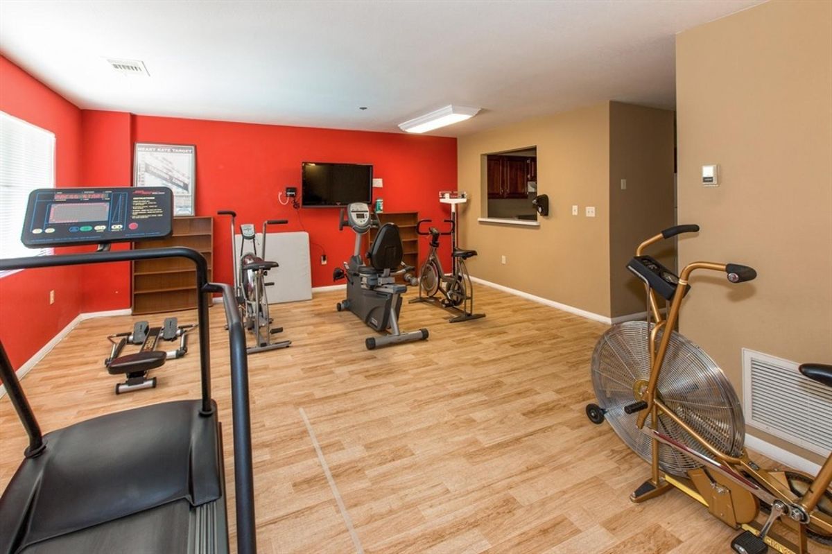 A well-equipped home gym with exercise bikes and a television.