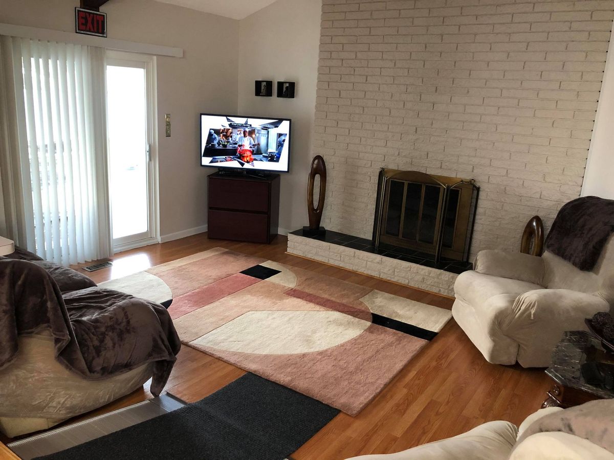 A cozy living room featuring a television, fireplace, and modern decor.