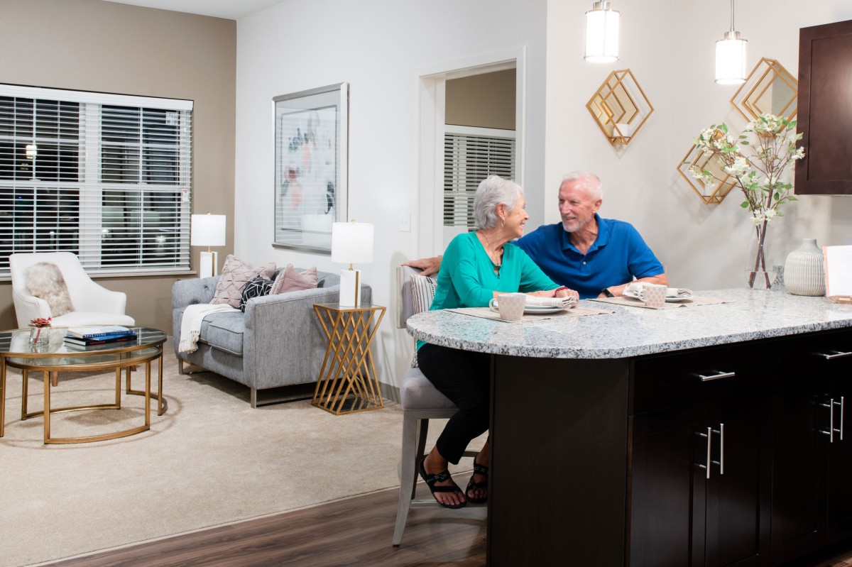 Elderly couple enjoying a meal in a cozy home setting.