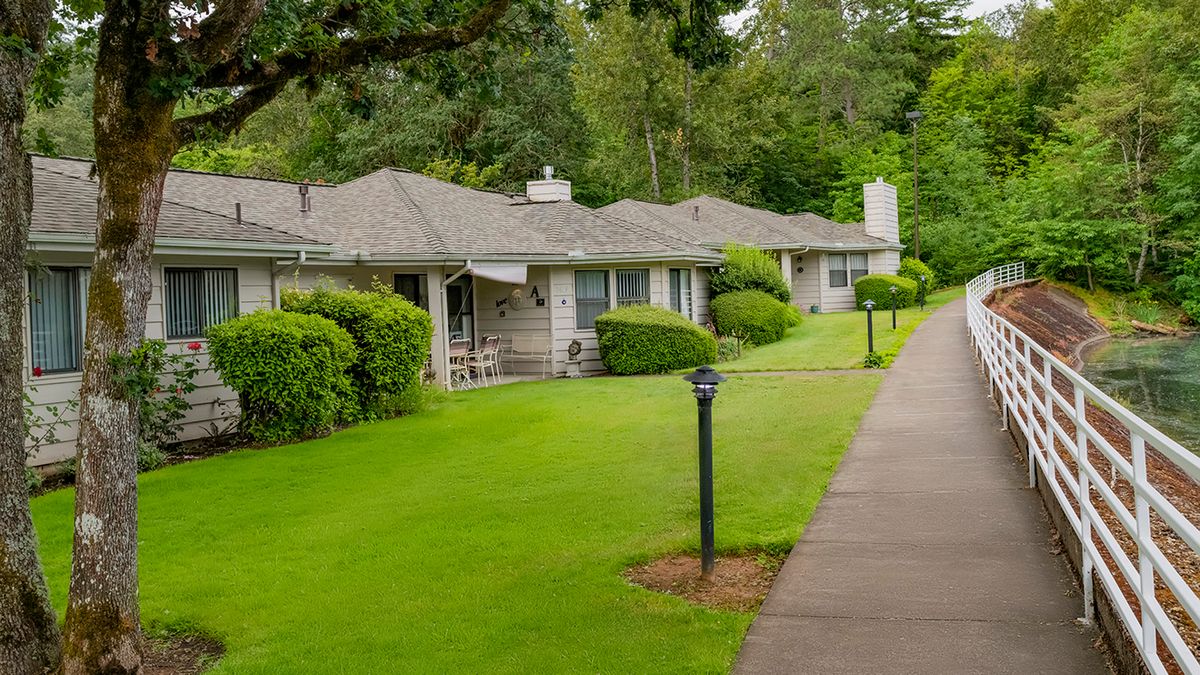 A peaceful residential area with neatly trimmed lawns and a sidewalk.