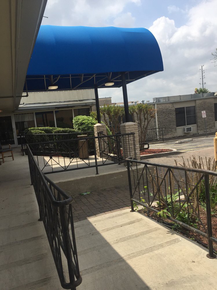 A walkway with a blue awning leading to a building entrance.