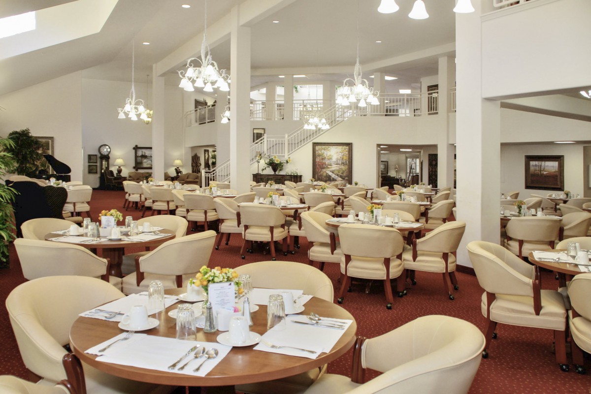 An elegant restaurant dining area with neatly arranged tables and chairs under soft lighting.
