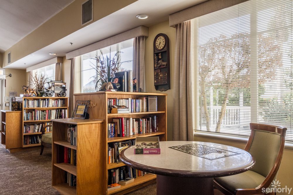 A cozy library corner with bookshelves and large windows letting in daylight.